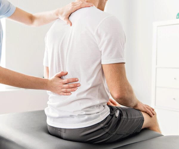 A physician checking on a patient's backpain
