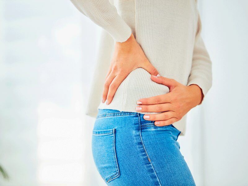 A woman holding her back