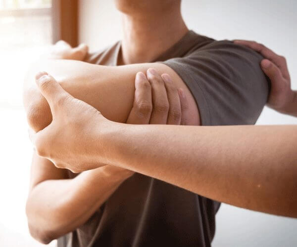 A man stretching with the help of a doctor